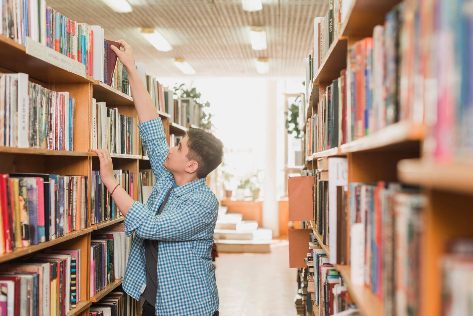 teenager-taking-book-from-bookshelf
